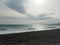 Seagull flying over pebble beach of Nice, France with azure waves of mediterranean sea