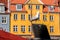 Seagull on historic ship in front of colorful house