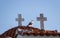 Seagull on the roof of a small church, standing between two crosses