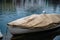 A seagull sitting on a covered rowboat dingy tied up on the Reuss river.