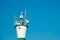 A seagull standing on a lighthouse with blue sky background. Navigation, route or direction