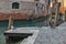 A seagull on the Venetian canal on a sunny winter day with a glimpse of the Venetian houses, water canal and a typical Gondola