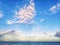 Seagulls birds flying in sky above sea ocean water on summer sunset. Outdoor nature fauna. Blue sky with large unusual shape pink