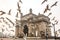 Seagulls fly in front of Gateway of India