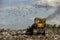 Seagulls fly over piles of garbage. A bulldozer tractor works at a large landfill near Kyiv, Ukraine. May 2016