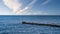 Seagulls on a groyne in the Baltic Sea. Waves and blue sky. Coast by the sea