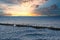 Seagulls on a groyne in the Baltic Sea. Waves at sunset. Coast by the sea. Animal