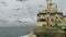 Seagulls soar behind a board of the fishing trawler.