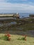 The Seahouses Lifeboat being launched at low tide with a Grassy bank and Red Poppy Flowers in the Foreground