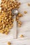 Sealing wax spoon and yellow gold sealing wax granules or beads a lot on wooden background. Vertical photo copy space, top view