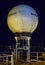 A Sealink Intellisan Satellite Communication Radome on the Top Deck of a Vessel lit up by Port and Ship Lights at night.