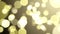 Seamless background animation of slowly flying defocused gold dust particles on a dark background with bokeh