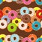 Seamless background with colorful donuts with glaze and sprinkles.