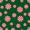 Seamless Christmas pattern with candy on green background.