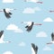 Seamless flying stork birds and clouds pattern