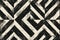 Seamless geometric pattern of black and beige triangles with a distressed texture, perfect for bold and contemporary