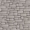 Seamless grey background wall of rectangular cracked bricks.