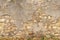 Seamless horizontal texture of an old wall made of rubble stone, brown sandstone, with the remains of cracked old plaster, a blank