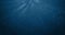 Seamless loop of deep blue ocean waves from underwater background with particles flowing movement, light rays shining