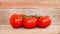 Seamless loop, fresh branch of tomatoes on wooden planks background, water trickles