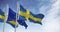 Seamless loop in slow motion of Sweden and the EU flags waving on a clear day