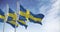 Seamless loop in slow motion of three Sweden flags waving on a clear day