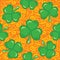 Seamless orange ornamental pattern with shamrocks