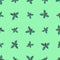 Seamless pattern of branches of Christmas holly with berries on a green background.