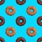 Seamless pattern of chocolate and nut donuts on blue background isolated top view, colorful donut repeating ornament, wallpaper