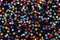 Seamless pattern of colourful stars confetti on black background