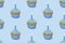 Seamless pattern with cupcakes with blue glaze on blue background, 3d rendering