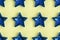 Seamless pattern from five pointed blue metallic star on yellow surface