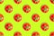 Seamless pattern of fresh ripe cherry tomatoes isolated on green background