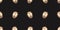 Seamless pattern with golden painted easter eggs with stripes on black background