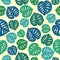 Seamless pattern with green,blue and aquamarine palm leaves on a beige background