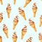 Seamless pattern with ice cream in the waffle cone with vanilla and caramel taste on soft blue background. Hand drawn