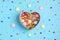 Seamless pattern of mix colorful sweets - lollipop, meringue, chocolate, sprinkle, gift box shape of heart, blue background