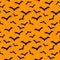 Seamless pattern orange background with black endless bat on hal