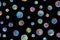 Seamless pattern of painted planets with shining watercolor paints on black background. Hand drawn bright watercolor circles