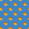 Seamless pattern of raw yellow eggs yolks on a blue background. Broken egg repeating ornament backdrop, Easter banner.