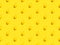 Seamless pattern from ripe juicy whole lemons on stem on yellow background. Tropical summer citrus fruits concept