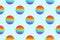 Seamless pattern of round rainbow silicone children`s toys antistress pop it or simple dimple on both sides on a blue background