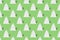 Seamless pattern of white clay Christmas tree toys in the form of Christmas trees on green background.