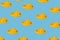 Seamless pattern of yellow plastic childrens boats on a light blue background
