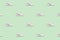 Seamless regular pattern of light colored casual sneakers on a mint background.