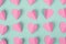 Seamless romantic background made of pink paper hearts on mint color background. Flat lay