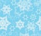 Seamless texture with snowflake fractal ornaments in light blue and white glitter.