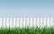 Seamless white fence with green grass on blue sky background. Garden fencing. summer backyard. traditional palisade or paling with