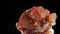 Seamlessly rotating a blood orange mineral Aragonite in front of black background