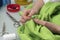 Seamstress sews the button to a green shirt